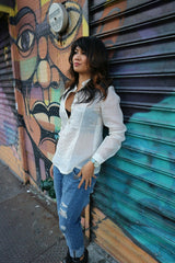 Amanda looking into distance in her custom long sleeve hand embroidered jusi Barong Tagalog and jeans at a storefront mural in Harlem, New York City