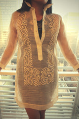 Product picture of dress length hand embroidered piña silk Barong Tagalog with bars and window behind her
