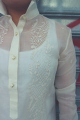 Product shot of Dom's left shoulder and chest area of her hand embroidered cocoon Barong Tagalog. The center button placket shows, the collar is standing up, and the left arm and sleeve shows also