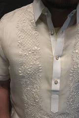Closeup shot of the right shoulder of the hand embroidered cocoon Lakhi Barong Tagalog. The barong's pointed collar and center button placket is also seen