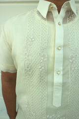 Closeup photo of the calado hand embroidery on the right side of the cocoon Marc Barong Tagalog. The collar and center button placket can be seen. 