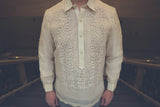 Product photo of the hand embroidered piña silk Mark Barong Tagalog. Mark stands at the top of a stairwell. There are bannisters on both sides and light brown marble walls in the background