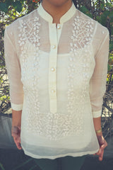 Product photo of the hand embroidered piña silk Mcihelle Barong Tagalog. Michelle wears a white tank top underneath the barong and green pants