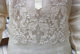 Closeup of the bottom of the calado hand embroidery on the piña silk Rodrigo Barong Tagalog. Rodrigo wears a chamisa de chino under his barong. Rodrigo stands at the High Line Park in New York City with wood stairs behind him