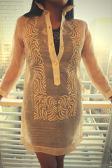 Product picture of dress length hand embroidered piña silk Barong Tagalog with bars and window behind her 