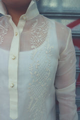 Product shot of Dom's left shoulder and chest area of her hand embroidered cocoon Barong Tagalog. The center button placket shows, the collar is standing up, and the left arm and sleeve shows also 