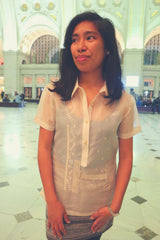 Ryann stands in main hall of DC Union Station in her jusi Barong Tagalog, tank top underneath her barong and grey skirt.