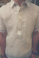 Product photo of the short sleeve hand embroidered cocoon Tiger Barong Tagalog. Tiger wears a chamisa de chino underneath his barong, a watch on his left wrist and a brown beaded bracelet on his right wrist 